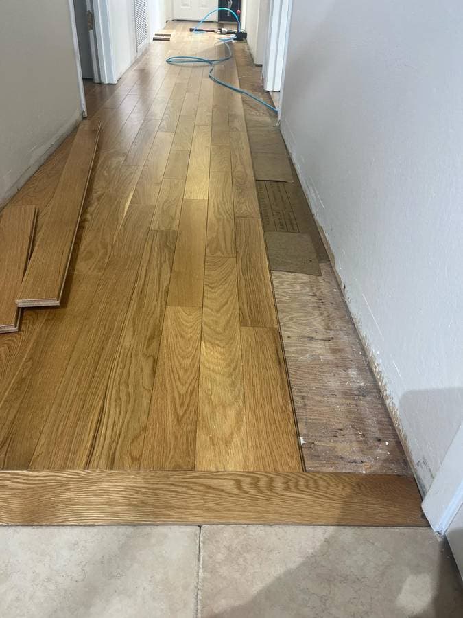Hardwood floor installation with clean plank alignment in residential hallway
