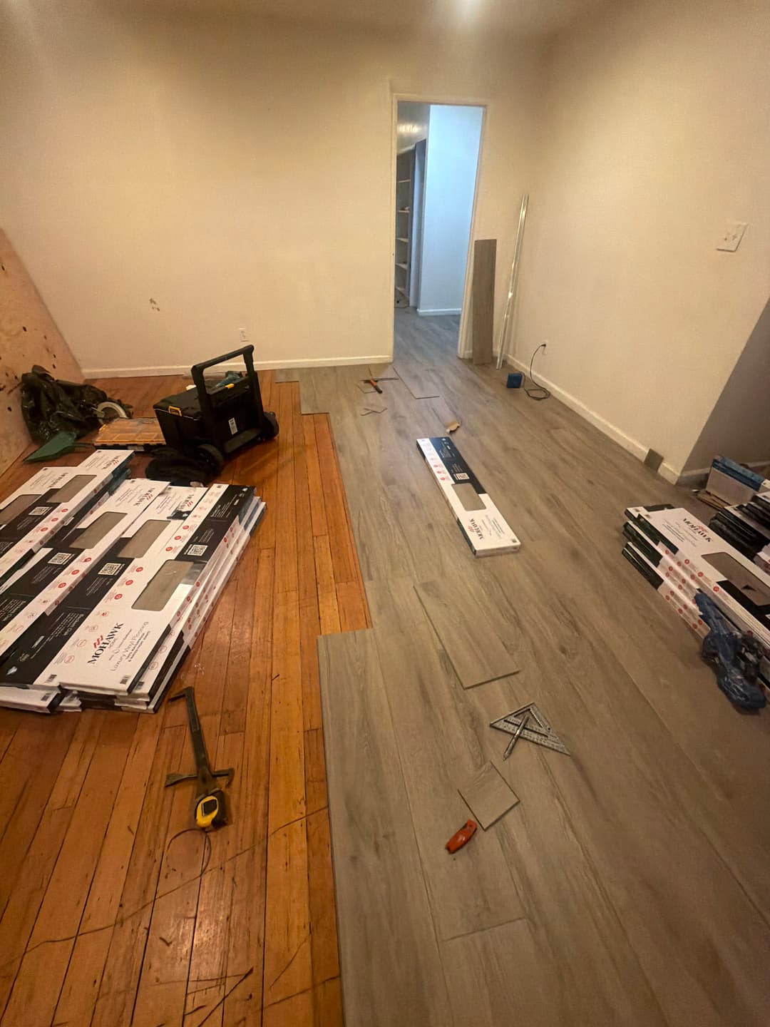 Hardwood floor installation in progress with planks laid across room