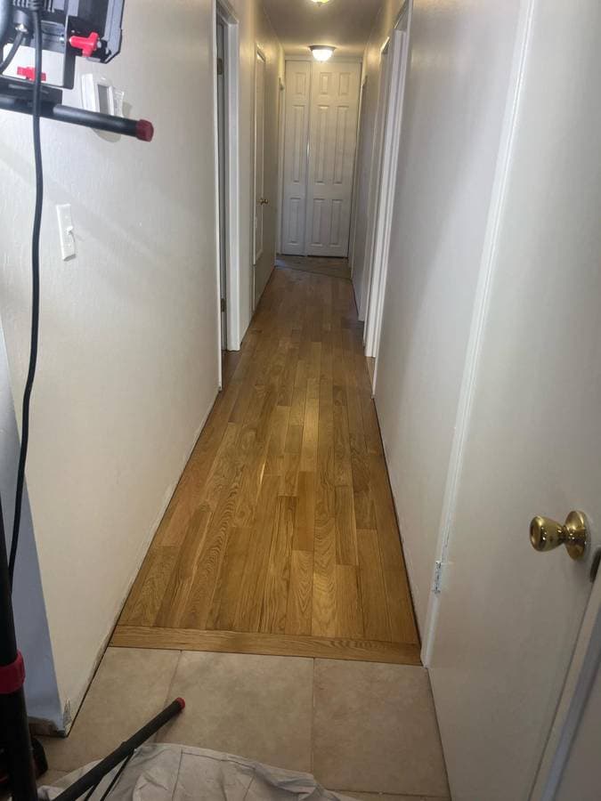 Narrow hallway hardwood flooring installation with smooth finish